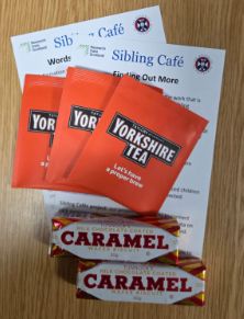 Photo shows 3 Yorkshire teabags, 2 Tunnocks caramel wafers, and 2 Sibling Cafe information sheets.