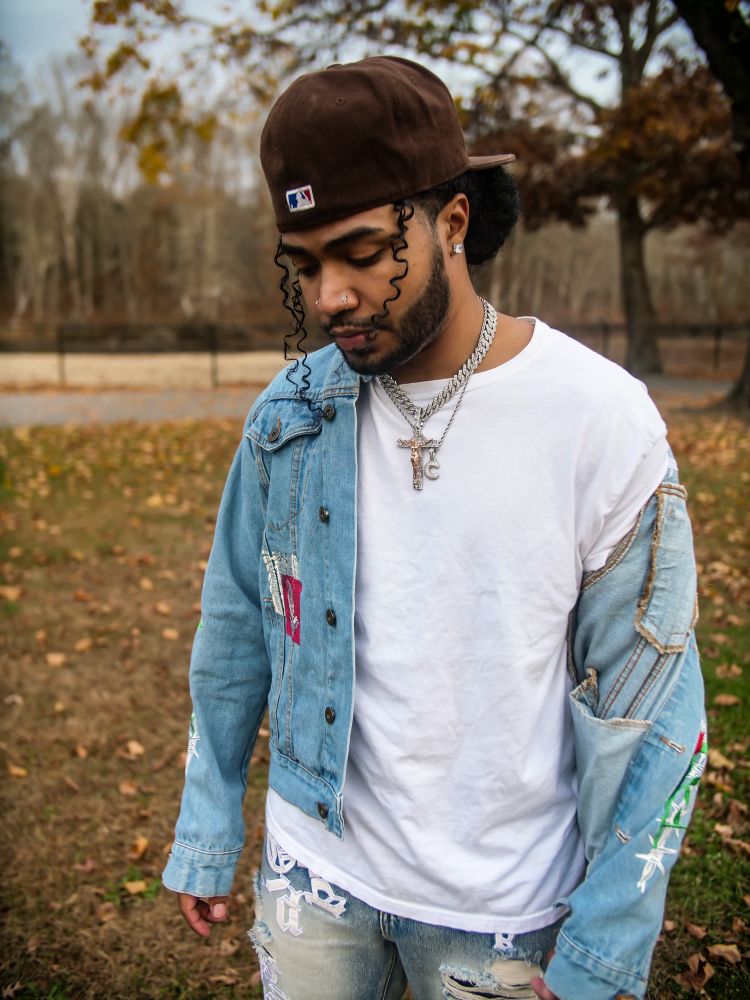 Famous rapper taking a professional picture in the open. Dressing in fashion with nice jean on jean outfit. 