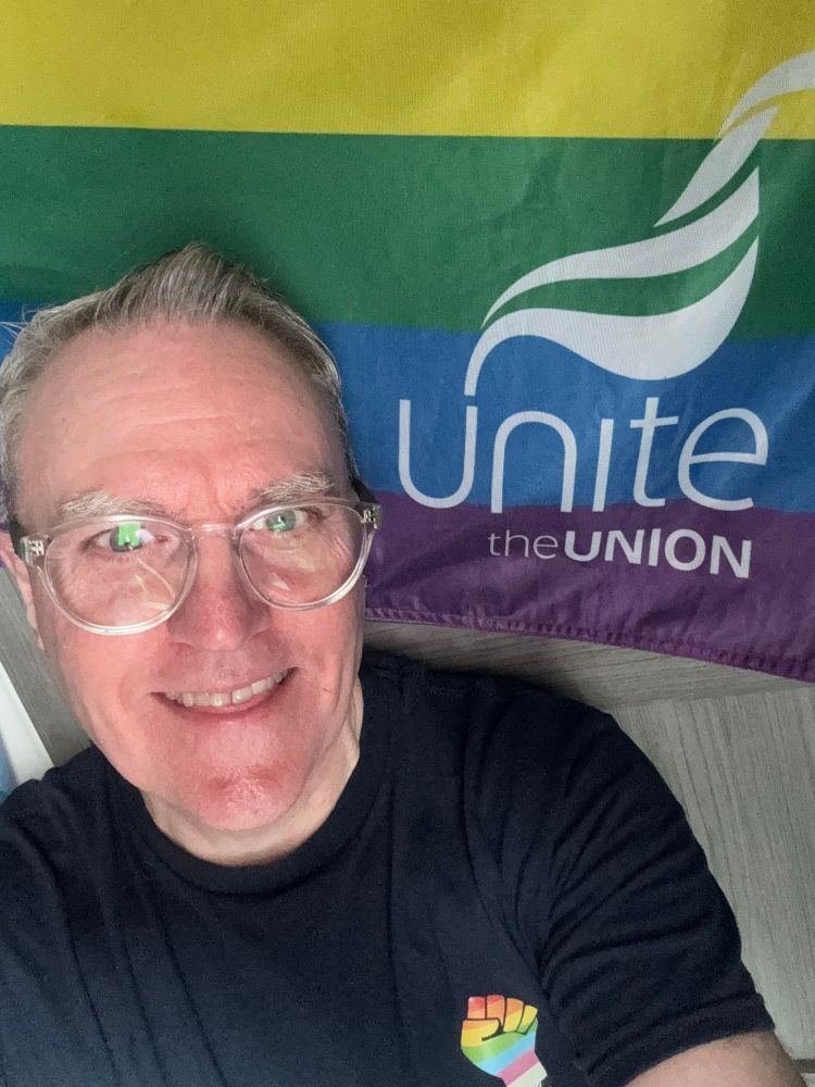 Man in front of Unite the Union pride flag
