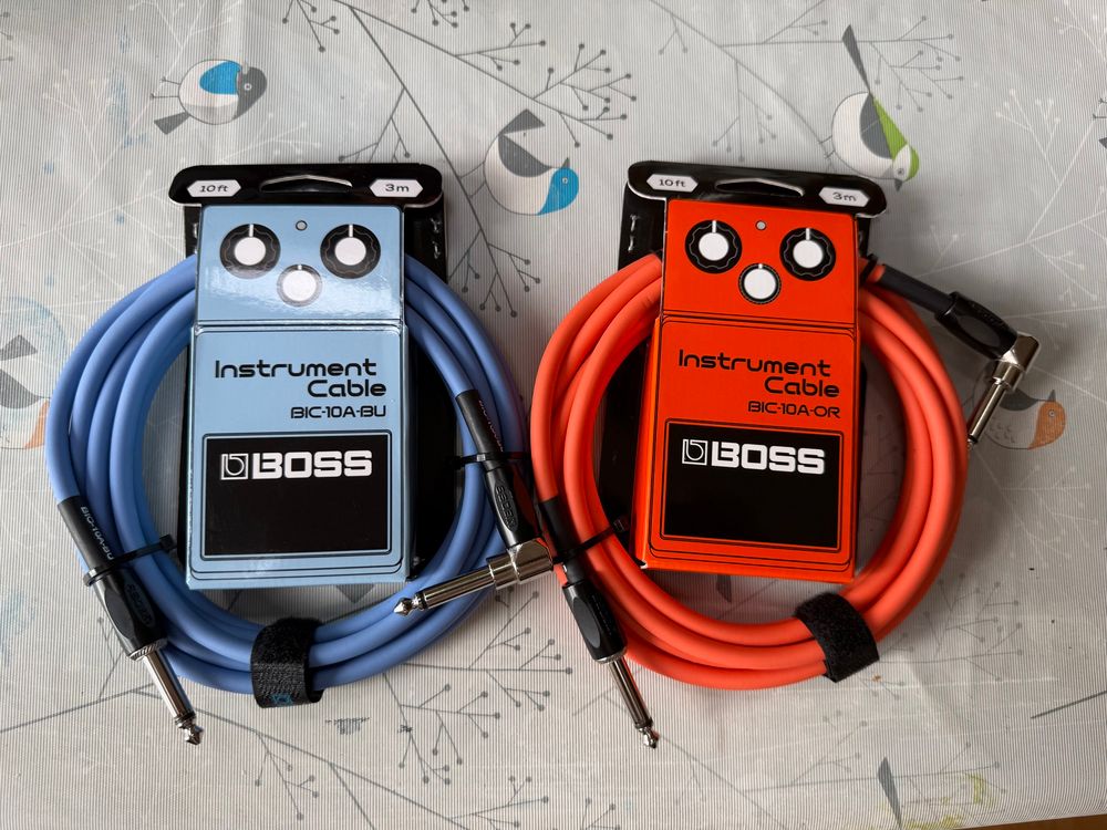 Two new Boss BIC-10A instrument cables in blue and orange. The packaging looks like a classic Boss stompbox guitar pedal. 