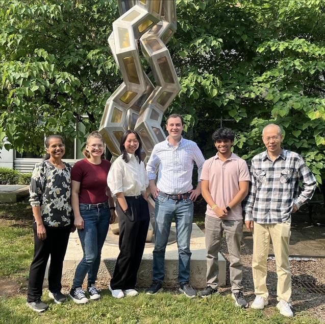 Team members and students in front of a collagen sculpture