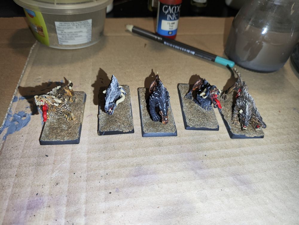 Cinco miniaturas de mastines del Caos pintadas. Las peanas tienen arena pegada pero aún sin pintar.