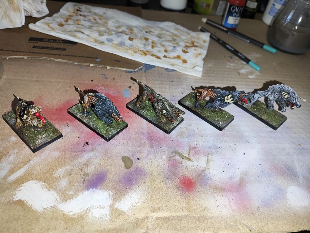 5 miniaturas de mastines del Caos, de Warhammer, pintados y con las peanas decoradas.