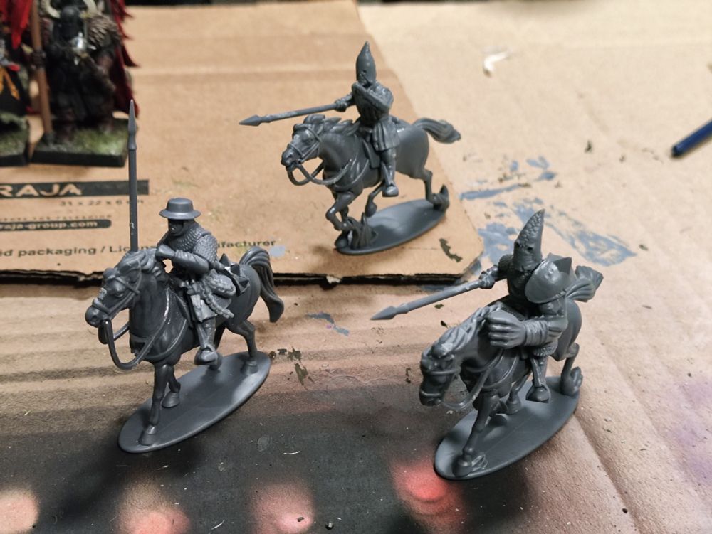 Tres miniaturas sin pintar de sargentos montados medievales, tuneados con capuchas de cultista, pinchos y uno de ellos con un brazo desproporcionadamente grande.