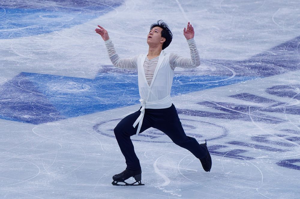 Adam Siao Him Fa, skating on one foot, both arms up