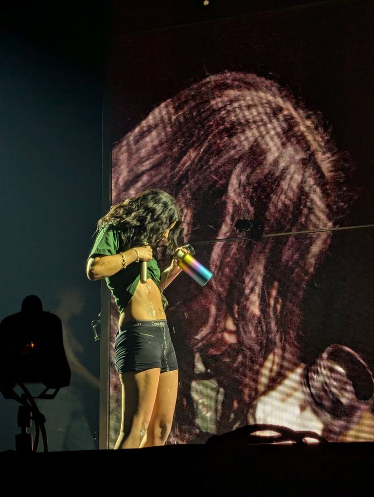 Lorde on stage at the OVO Hydro, pouring water over herself from her famous water bottle 
