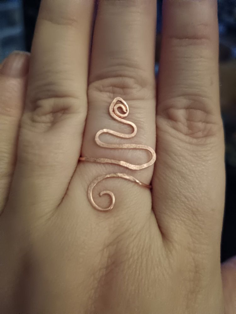 A snake ring made of copper wire of a middle finger
