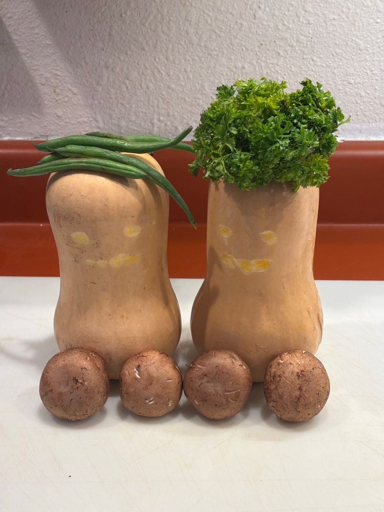 Butternut squash with a little carved face. Greens as hair and mushrooms boobs.