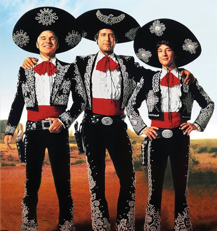 Steve Martin, Chevy Chase, & Martin Short in black & white embroidered costumes with pistols and sombreros as the 3 Amigos (from the film)