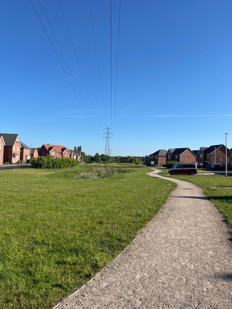 Green grass, a gravel path and blue sky. 