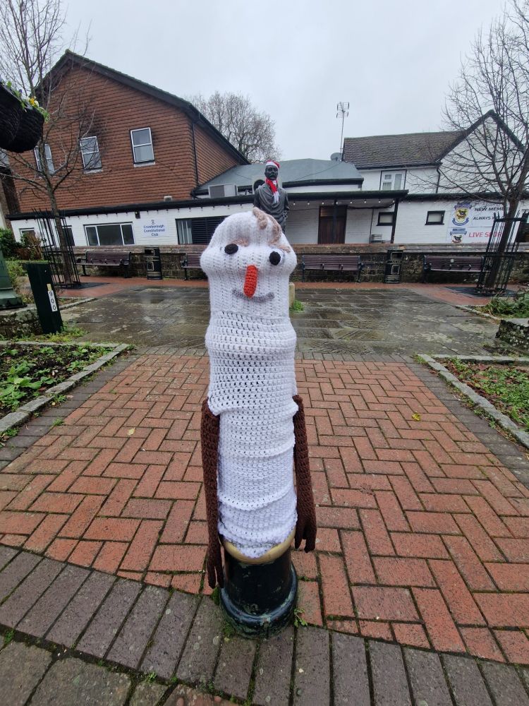 Knitted bollard cover of a snowman in Crowborough that looks like an upright penis. 
