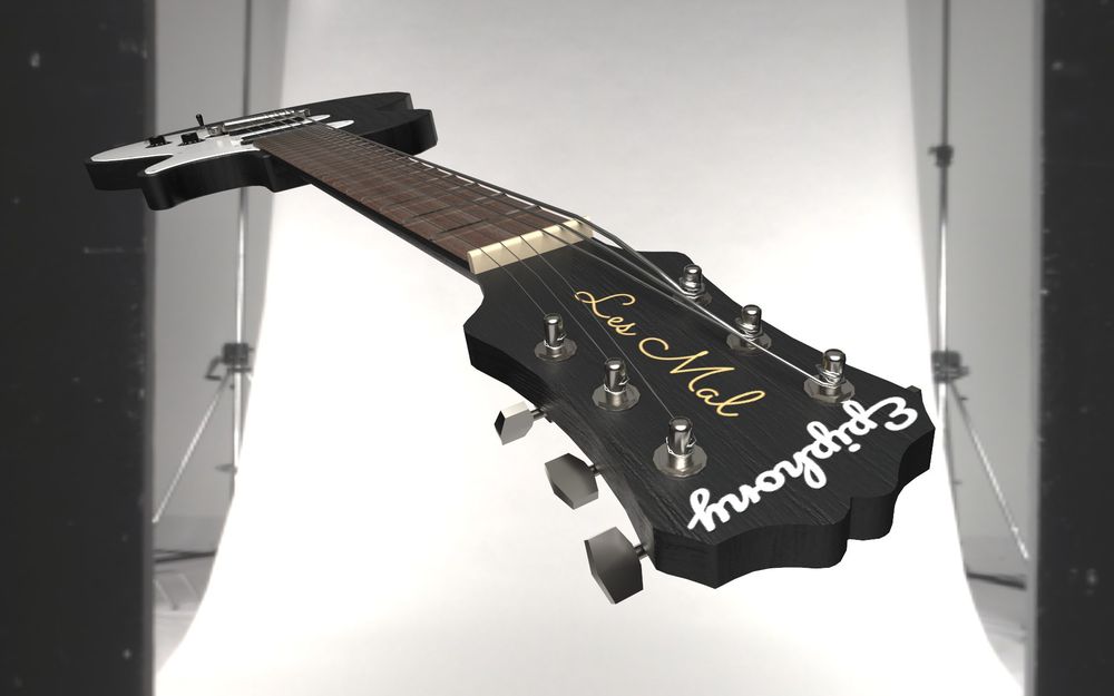 A black and white electric guitar against a white backdrop in a studio.