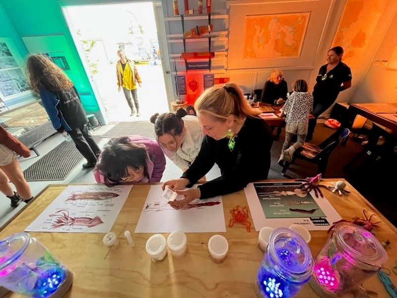 Professor Gretta Pecl AM showing two students a sample at the Beaker Street SquidFest in Tasmania. Credit: IMAS