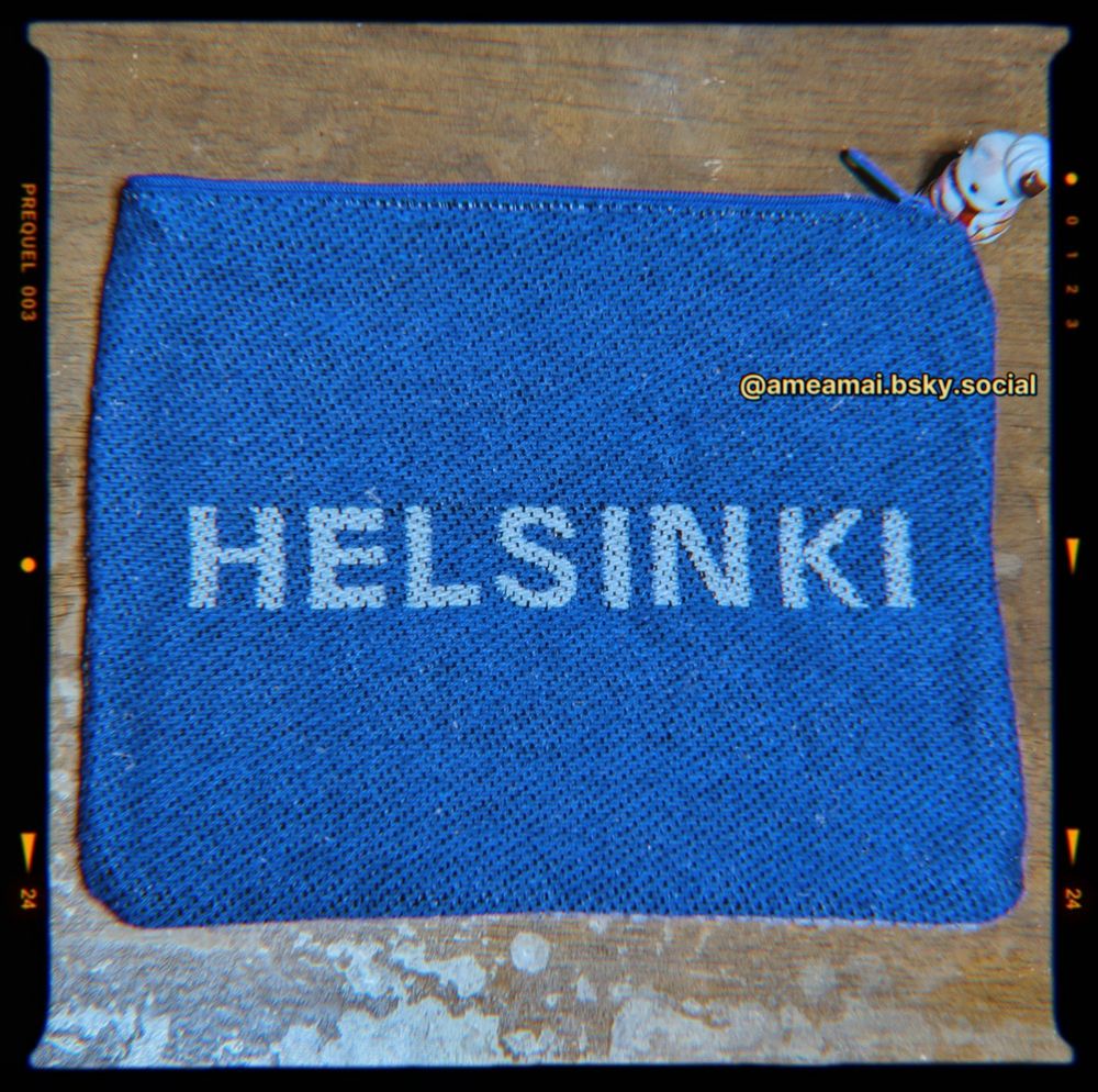 青地にグレーの文字でHELSINKIと入っている、横長のフラットポーチの写真です。