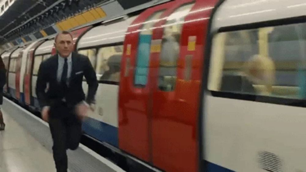 a man in a suit and tie is running to catch a train