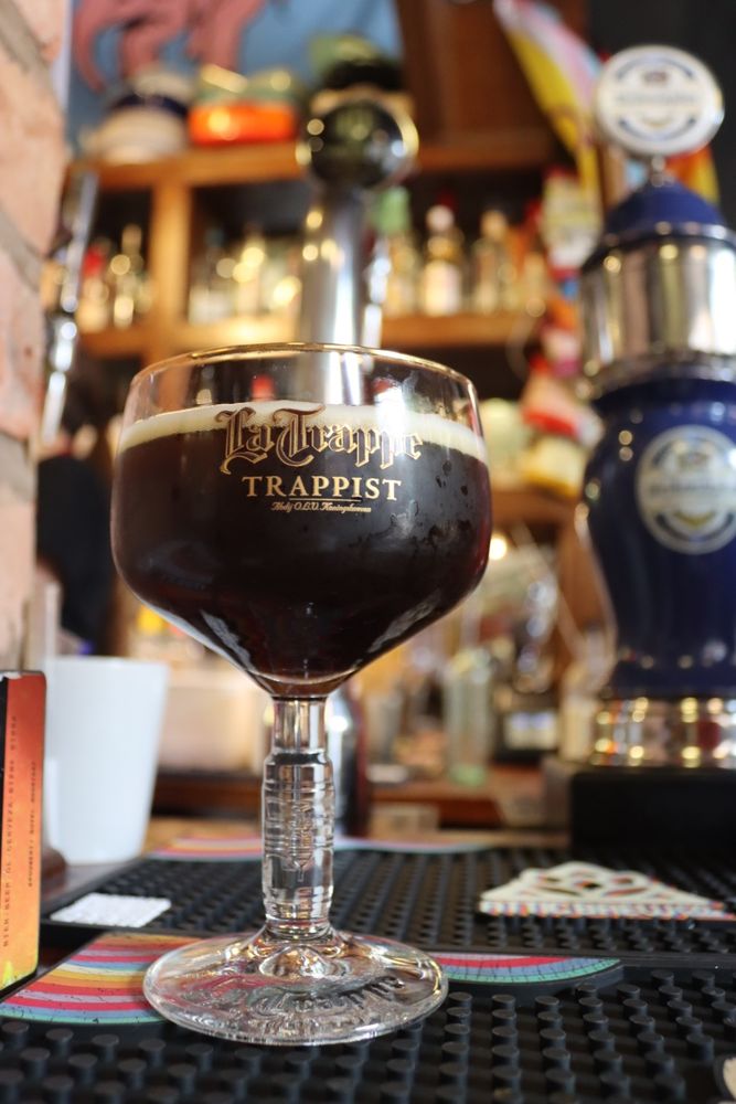 A half of the beer in a La Trappe stemmed glass.