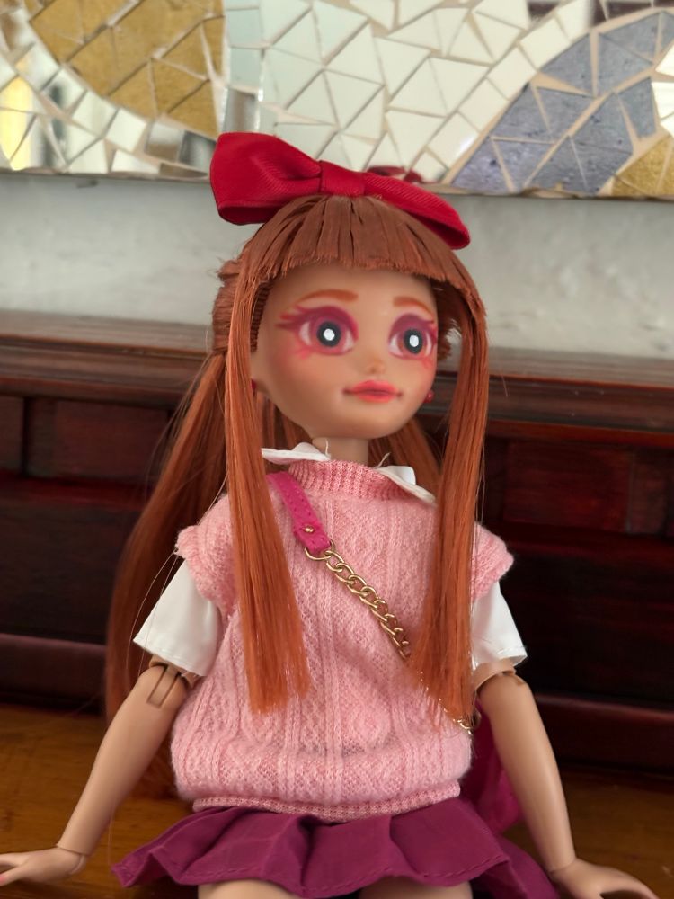 Another closeup of thr Blossom doll, this time she's sitting and it's from another angle. She's looking up.