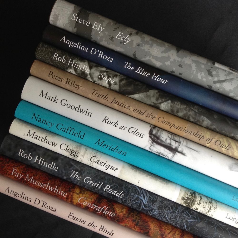 Ten Longbarrow hardbacks, stacked on a diagonal, spines facing outwards.