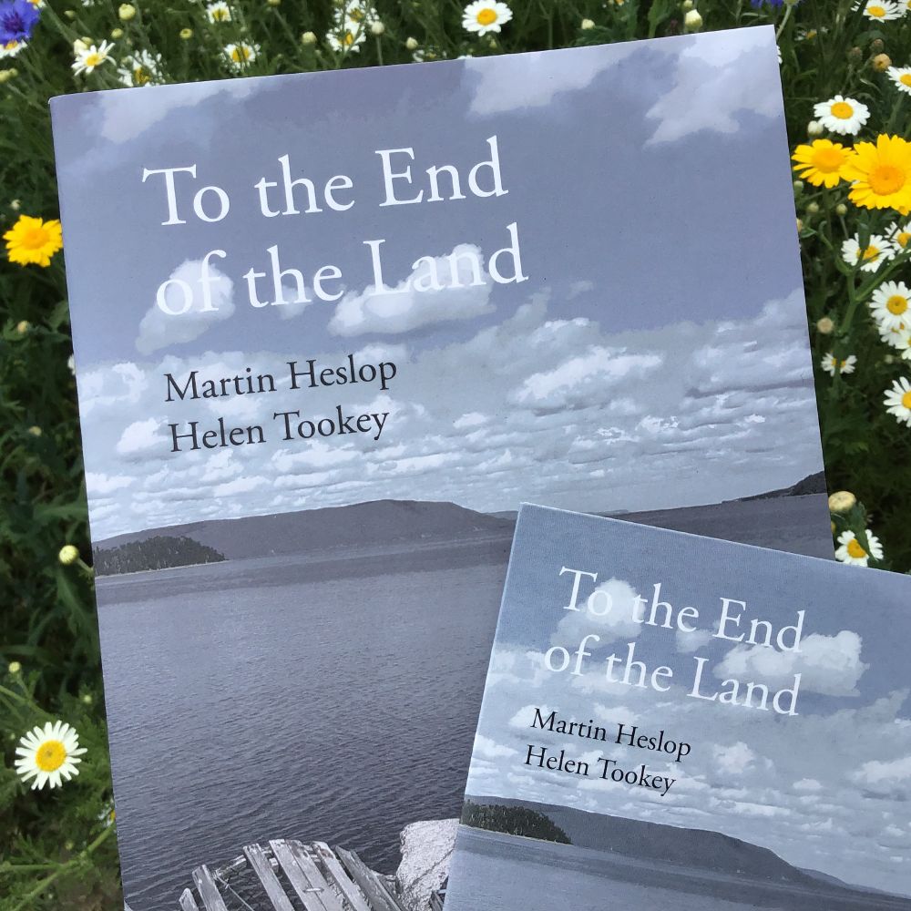 The pamphlet and CD editions of 'To the End of the Land' by Martin Heslop and Helen Tookey: the blue-grey coastal edge of Nova Scotia, with dilapidated wooden lobster traps in the foreground, sea and distant land beyond, and white clouds and blue sky above.