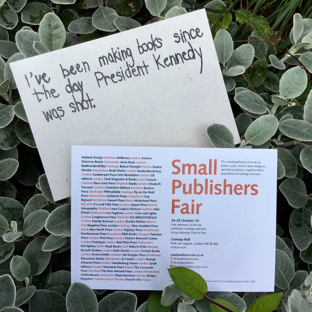Promotional cards for the 2025 Small Publishers Fair amongst euphorbia leaves in the publisher's garden.