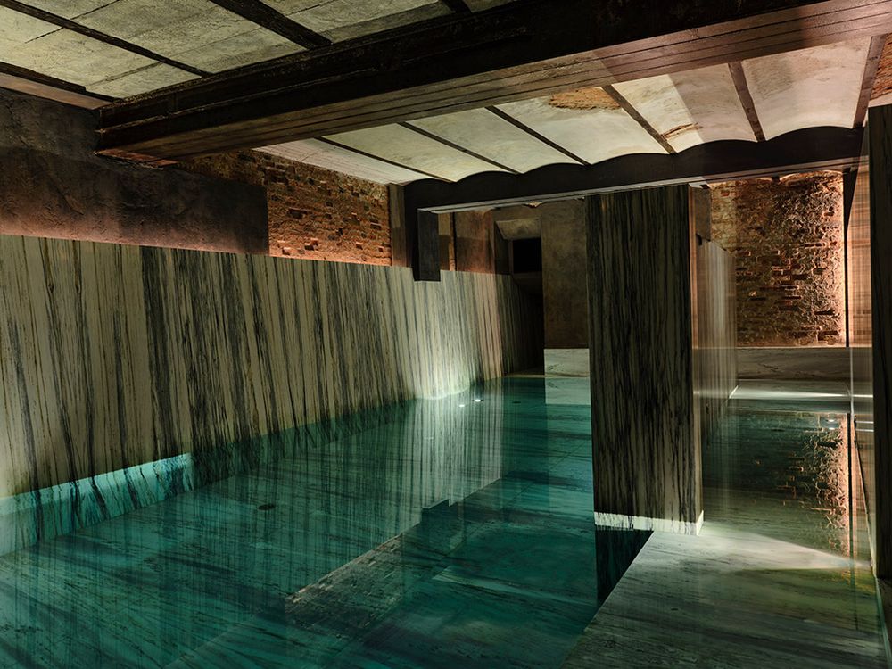 Photograph of a moody basement level marble swimming pool 