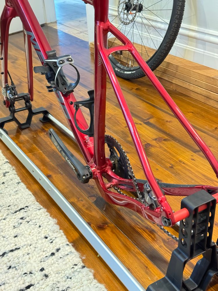 Red bike stripped and mounted on a railing system, ready to be placed into a bag for travel