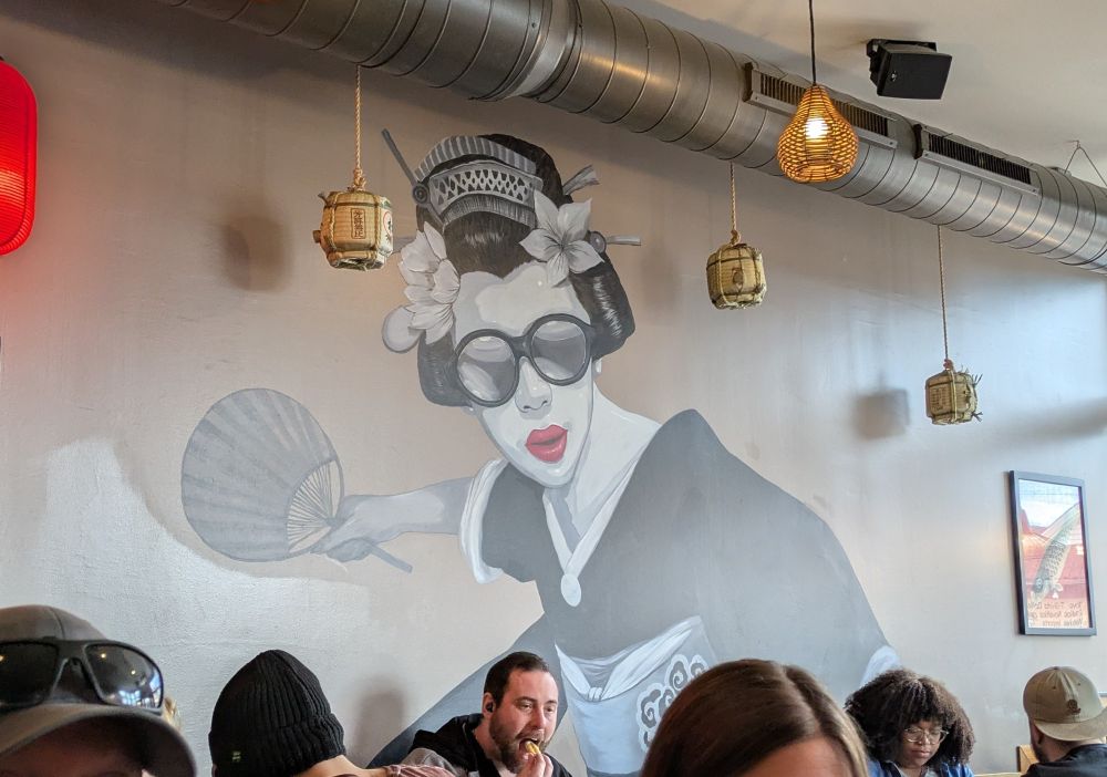 An interior wall of a Japanese restaurant in the Bay View neighborhood of Milwaukee, WI. On the wall is painted a cool geisha wearing mirrored sunglasses. 