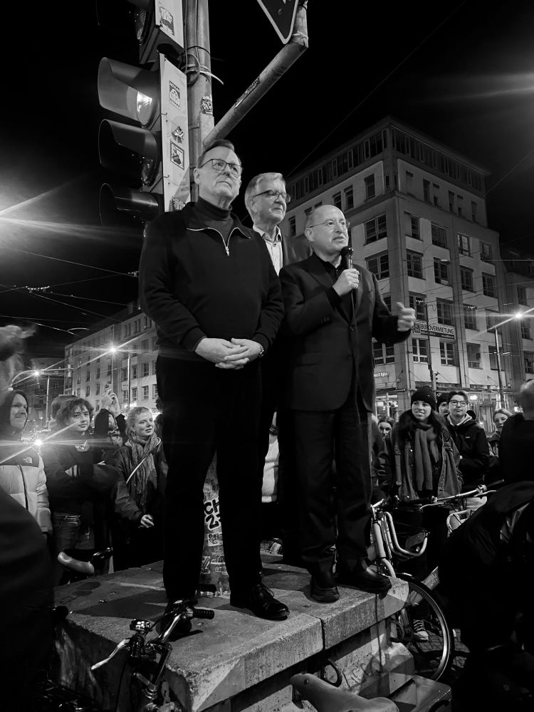 Ramelow, Gysi, Bartsch stehen an einer roten Ampel auf einem Podest. Sie sprechen in Dresden zu allen die nicht in die überfüllte Veranstaltung  reingekommen sind.