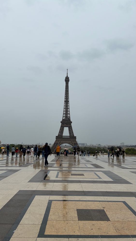 A picture of the Eiffel Tower from a distance on a rainy day in Paris. 