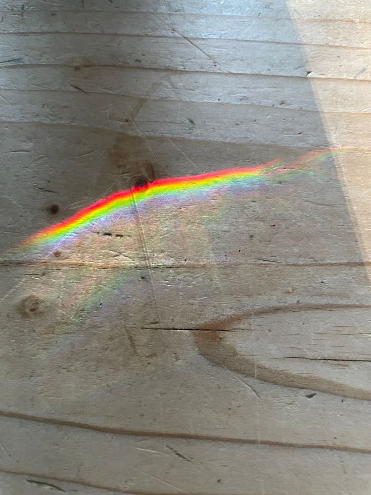 A wooden table with a small line which is a prism. 