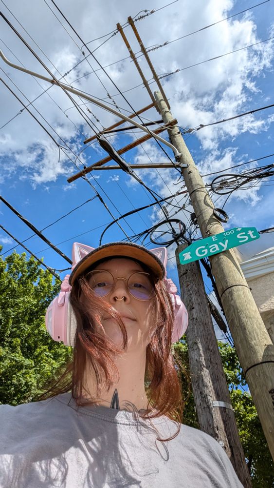 Selfie in front of Gay Street sign wearing pink cat ear headphones and a baseball cap. Also, I love Giant Women 