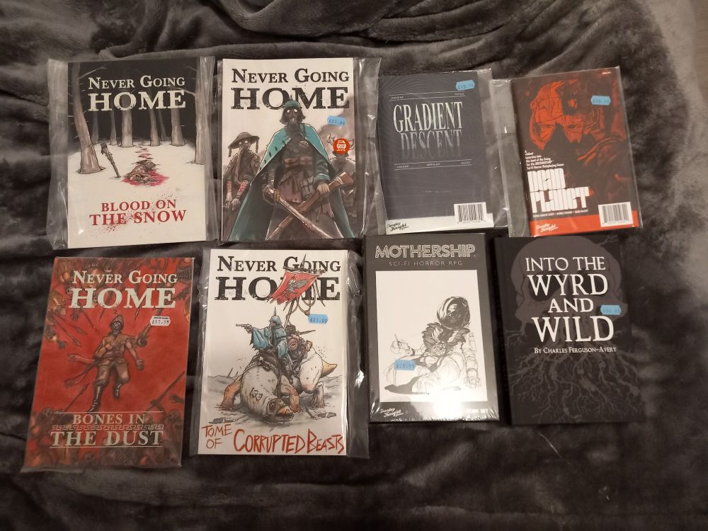 Photos de plusieurs jeux de rôle : Mothership et deux suppléments, Into the Wyrd and Wild, Never Going Home et ses suppléments 