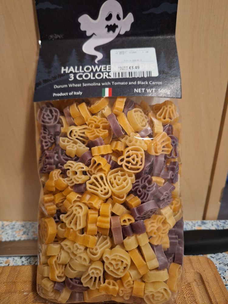 a bag of multicolored pasta in shapes ofbats, ghosts, spiders and halloween pumpkins