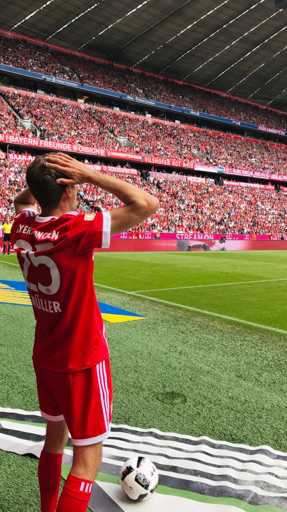 Thomas Müller holds his hands above his head at Allianz Arena. 