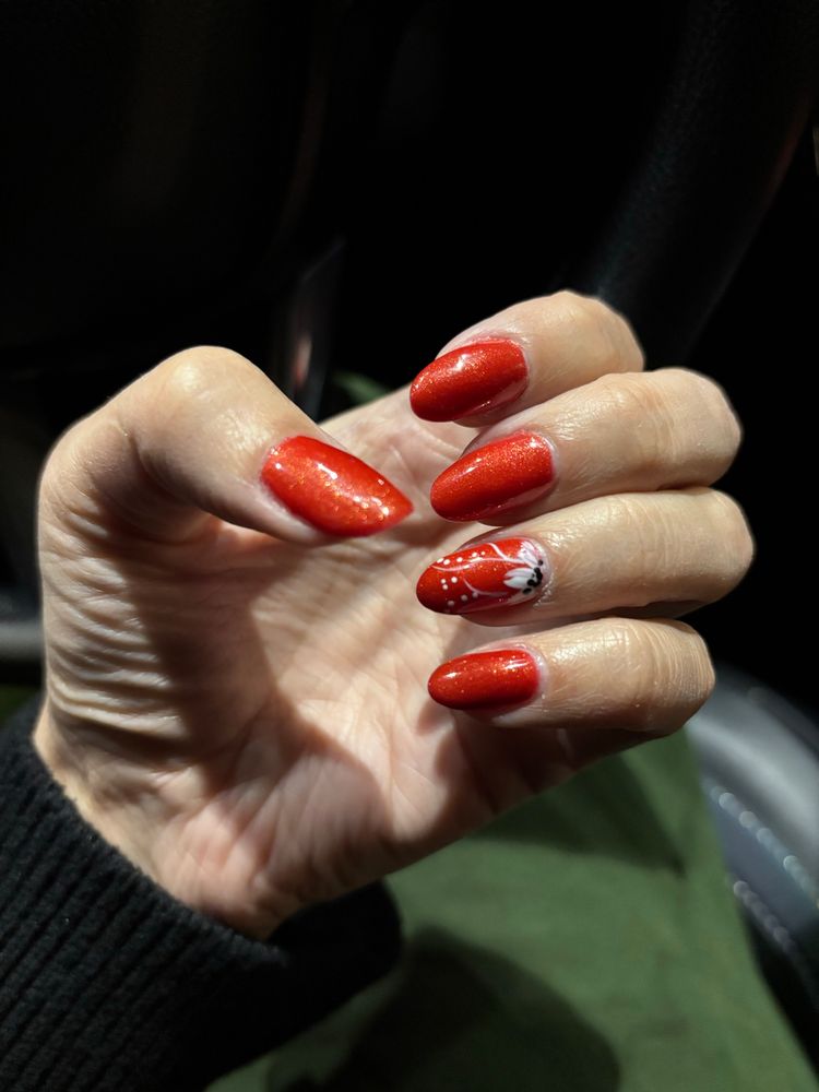 Painted nails with nail art of a flower on one finger 