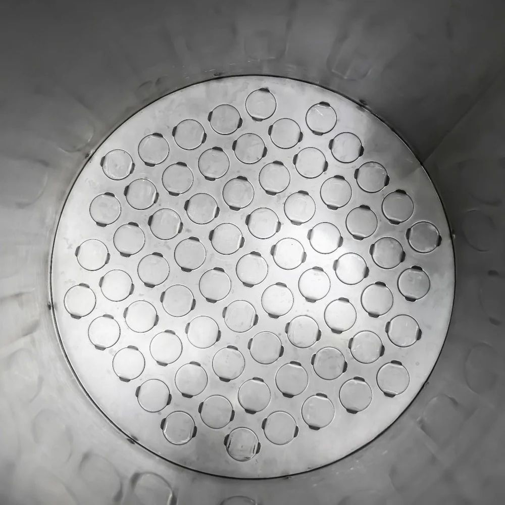 A picture of the inside of a solid stainless steel basket, with a dimple like bottom