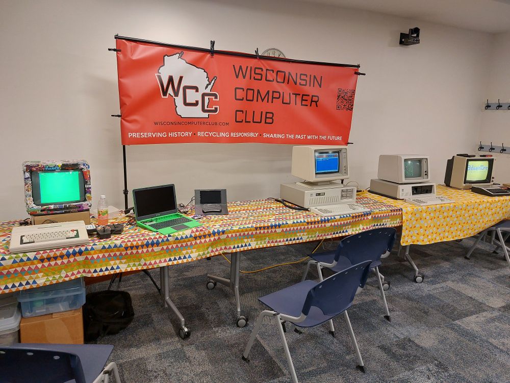 The Wisconsin Computer Club banner set up over member displays at our Janesville Pop-Up Museum show. From left to right, TRS-80 Color Computer 2, Pi-Top laptop, IBM PC AT, IBM PC XT, TI-99/4A.
