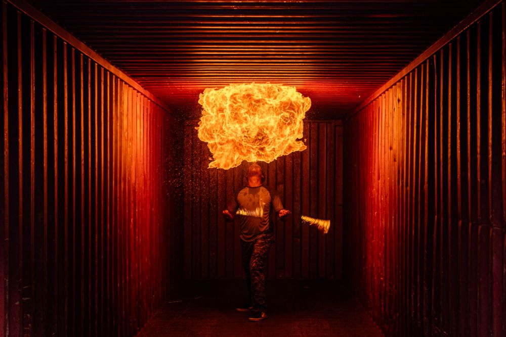 A photo taken by photographer Adam Scott at an Atlanta Shooters event. There was a fire breather on site who agreed to breath fire inside a container. But he could only do it once due to the risk of oxygen loss. So Adam had one shot, one chance to get this photo right. 
