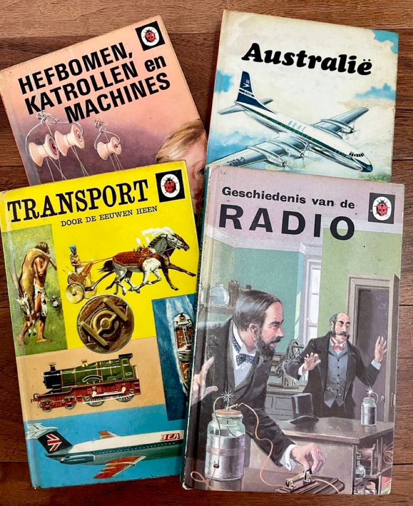 The front covers of four vintage ladybird books: Radio, transport through the ages, Australia and ‘levers, pulleys and engines - but all 4 are the Dutch translation version 