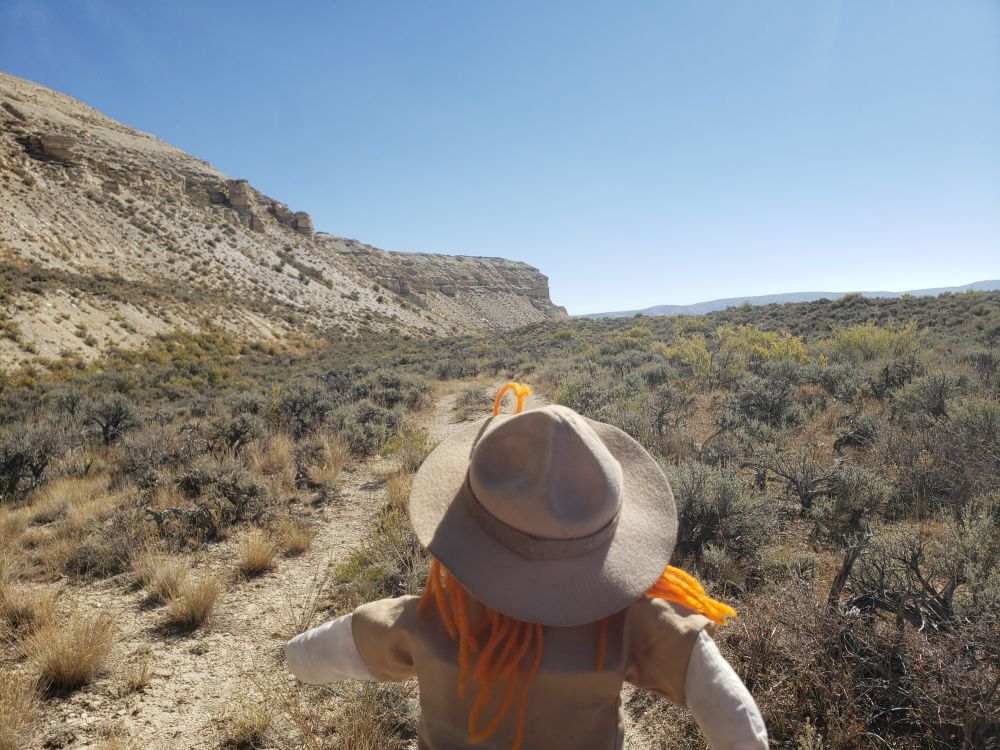 Ranger Sarah continues her hike along the Historic Quarry Trail. Above her is the limestone bluff which contains the fossil bearing layers.
— at Fossil Butte National Monument.

