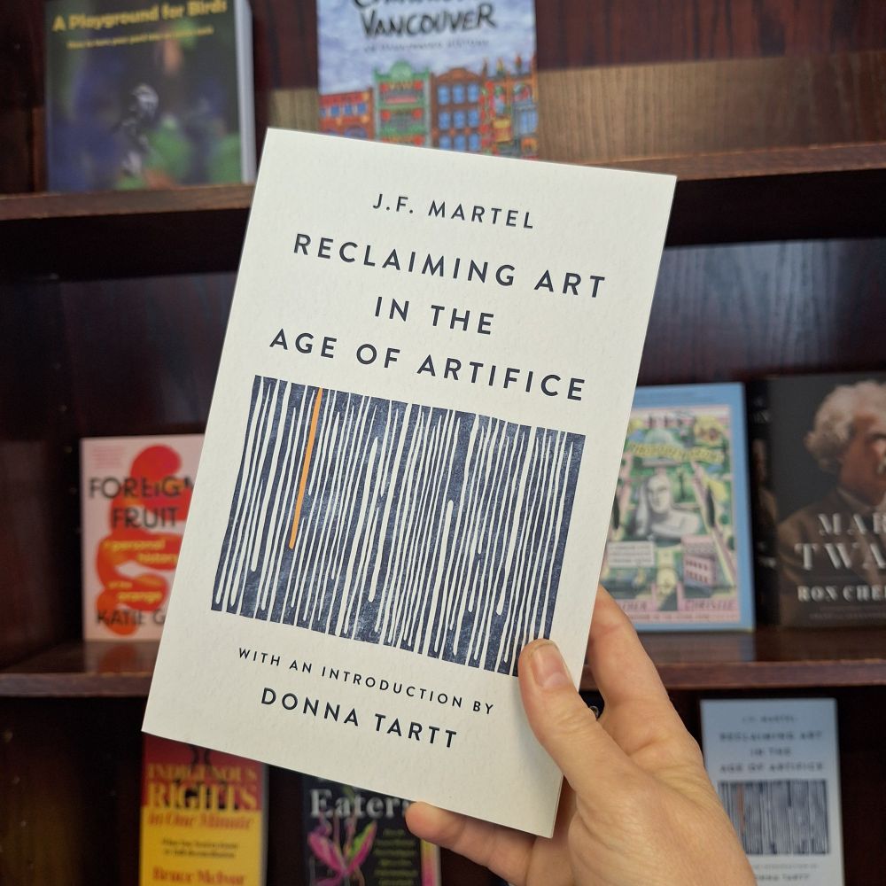 A hand holds up a book titled 'Reclaiming Art in the Age of Artifice' by J.F. Martel, with an introduction by Donna Tartt.