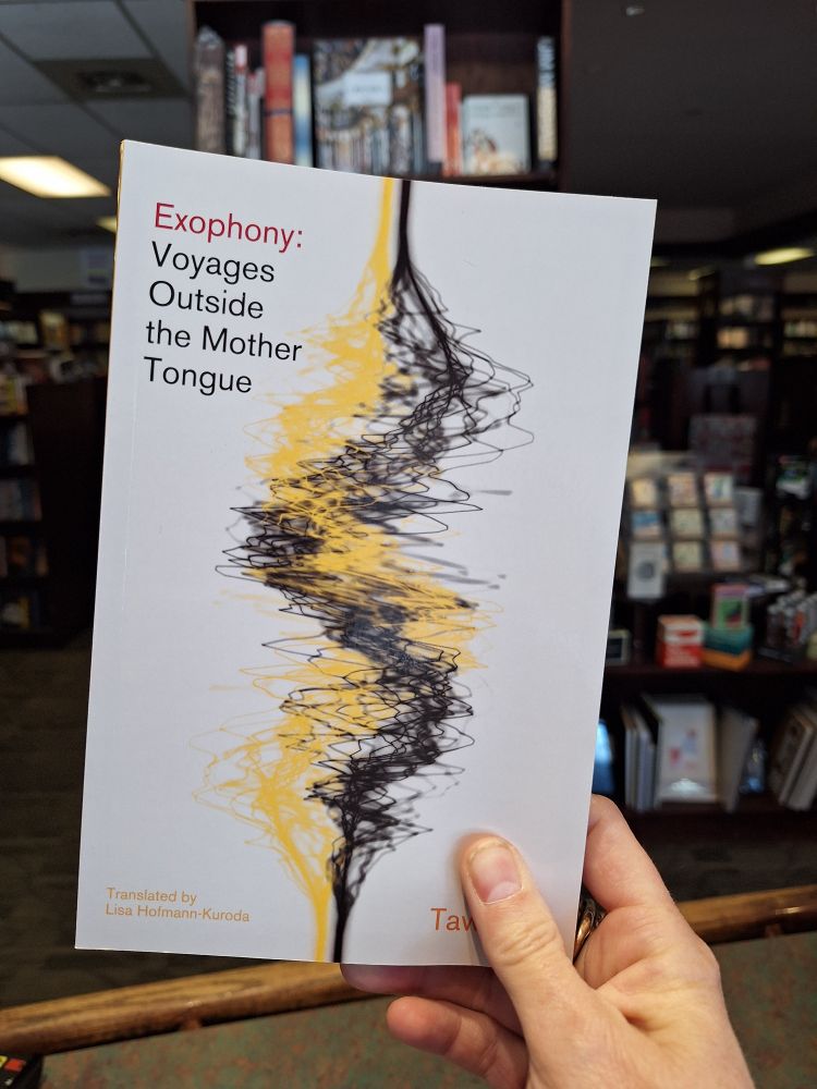 A hand holds a copy of Exophony: Voyages Outside the Mother Tongue by Yoko Tawada.
