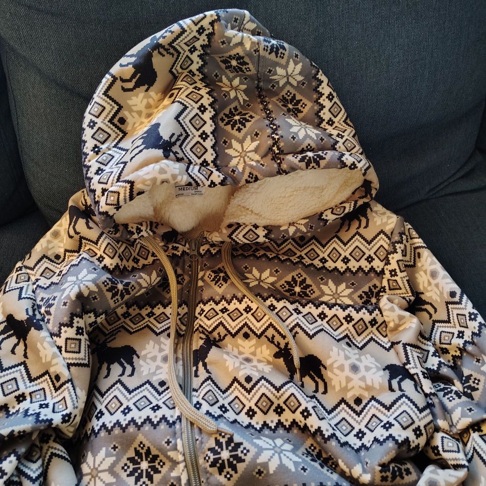 A hoodie that has winter themed designs on it with reindeer and snowflakes. The inside is very fluffy.