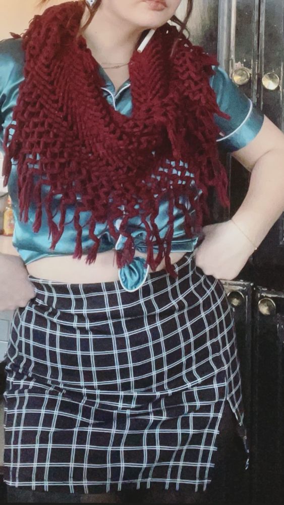 up close of black and plaid skirt, teal silk shirt, and burgundy scarf outfit with black tights.