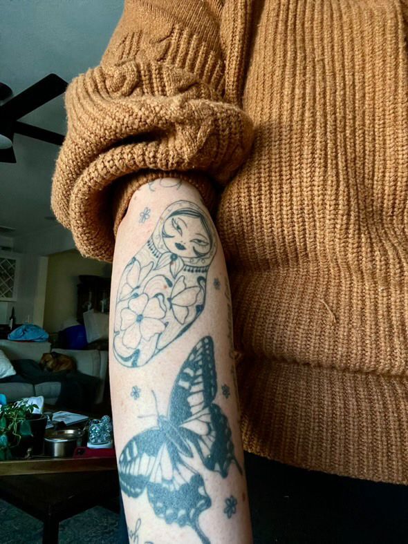 Healed nesting doll, butterfly, and tiny filler flower tattoos 