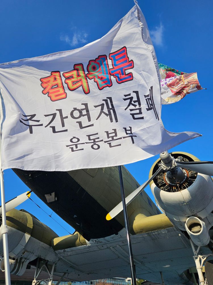 시위 현장에 컬러웹툰 주간연재 철폐 운동본부 깃발이 휘날리고 있다.