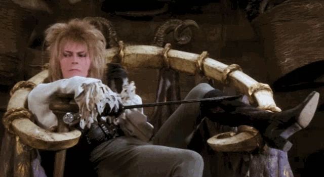 header image - a man with horns is sitting in a chair with a sword in his hand