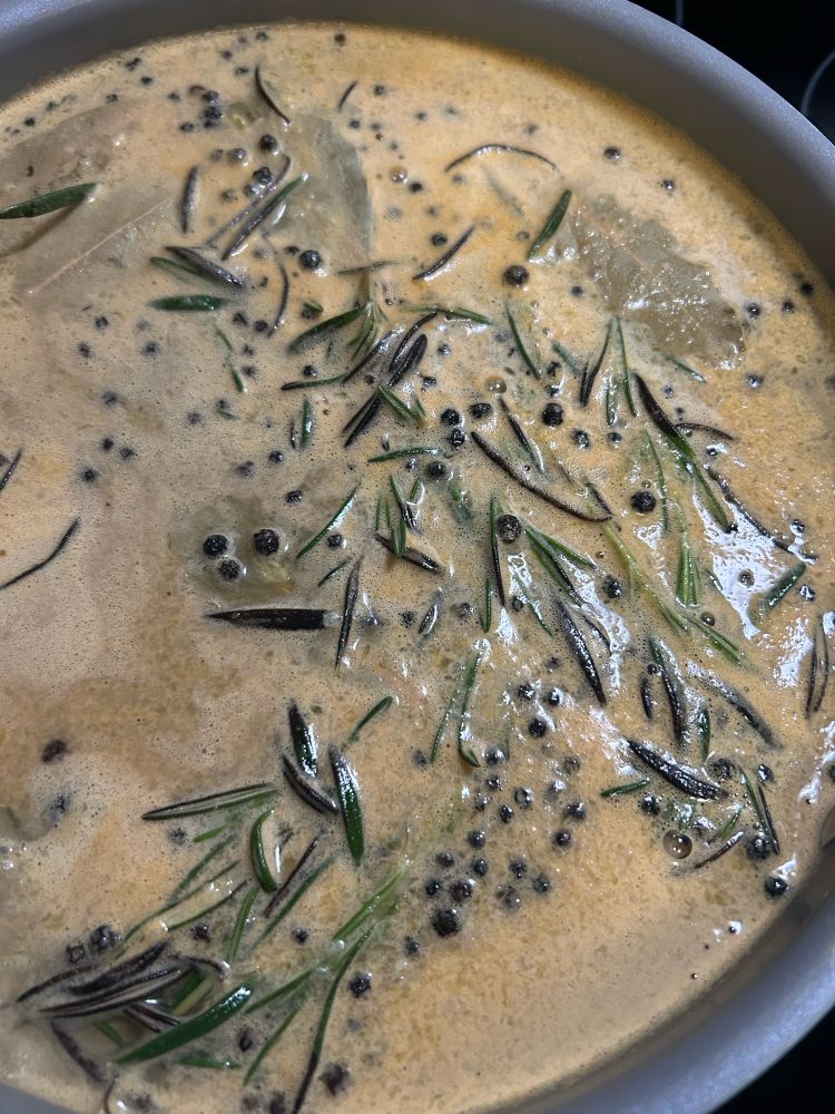 a simmering pot of water, salt, apple cider, rosemary, peppercorns, orange juice, brown sugar, and garlic