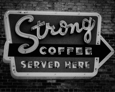 B&W photo of vintage neon sign that says “Strong Coffee served here.”