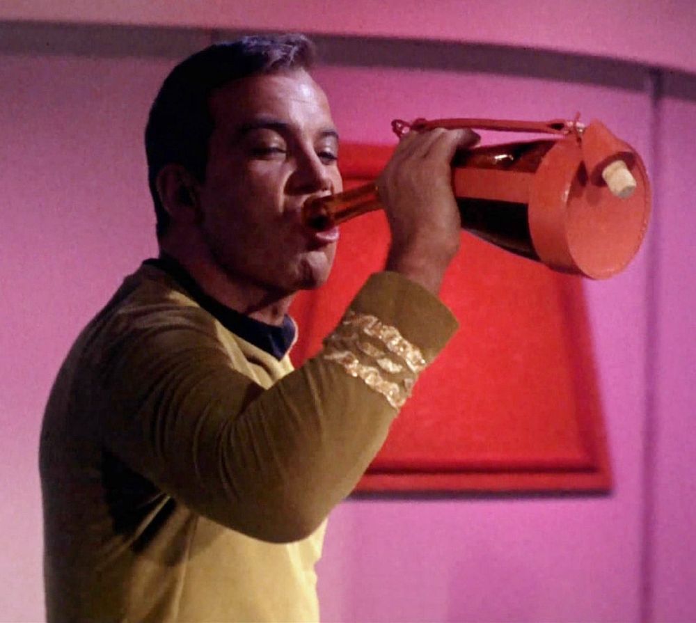 Captain Kirk Bogarts a bottle of Saurian brandy.